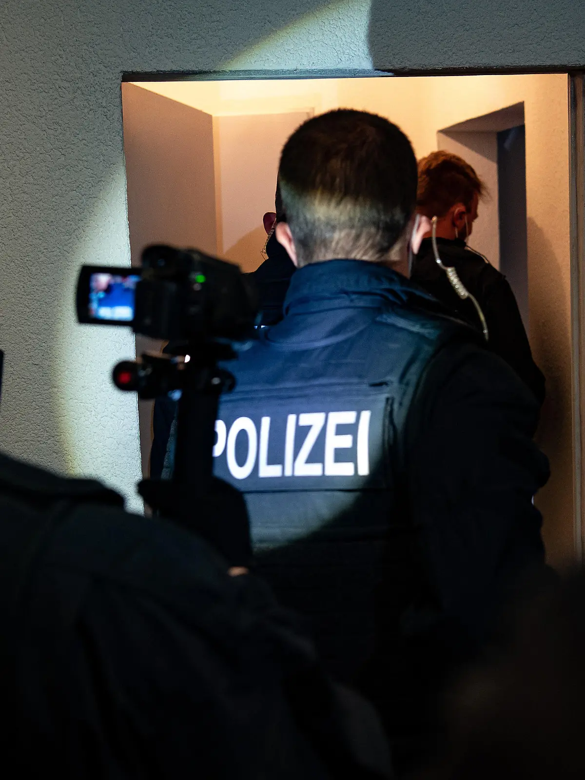 31.05.2021, Berlin: Bundespolizisten gehen bei einer Razzia gegen Schleuser in eine Wohnung. Bei einer großangelegten Razzia gingen Bundespolizisten in mehreren Bundesländern gegen Schleuserkriminalität vor. (Zu dpa «Bundesweite Razzien gegen organisierte Schleuserkriminalität») Foto: Paul Zinken/dpa-Zentralbild/dpa +++ dpa-Bildfunk +++