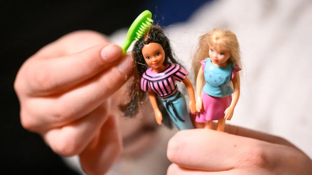ILLUSTRATION - 20.11.2022, Hamburg: Eine junge Frau kämmt die Haare von zwei der größeren Polly Pocket Puppen. (zu dpa ««Das hatte ich auch mal» - Retro-Spielzeug im Trend») Foto: Jonas Walzberg/dpa +++ dpa-Bildfunk +++