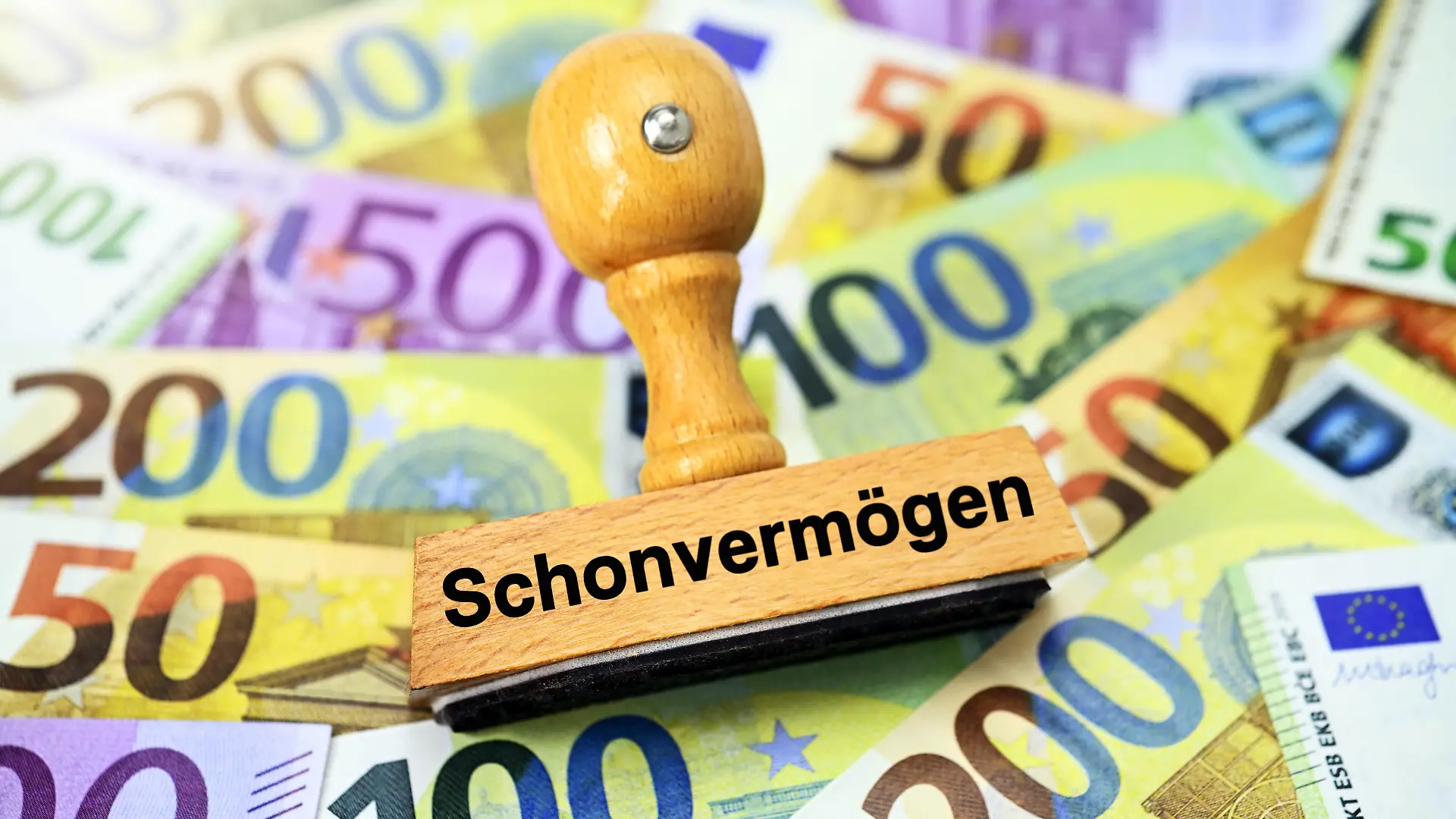Stempel mit Aufschrift Schonvermögen auf Geldscheinen / action press