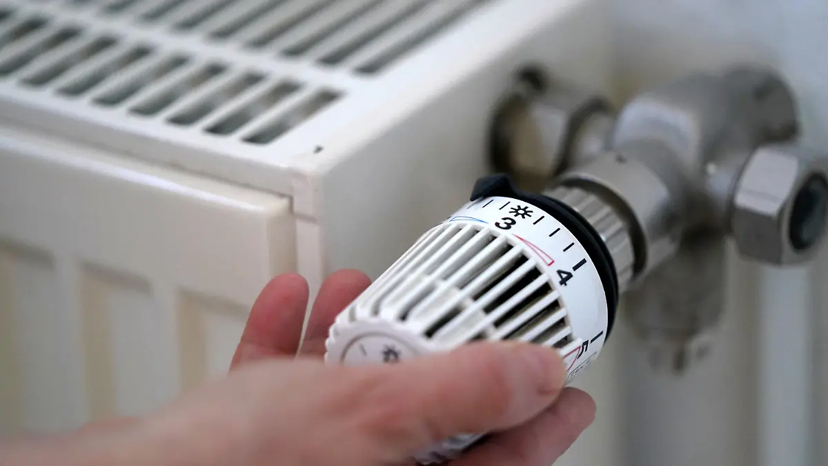ARCHIV - 09.03.2022, Hamburg: ILLUSTRATION - Eine Frau dreht an einem Heizungsthermostat. (zu dpa: «Vermieter müssen sich an Klimaabgabe fürs Heizen beteiligen») Foto: Marcus Brandt/dpa +++ dpa-Bildfunk +++