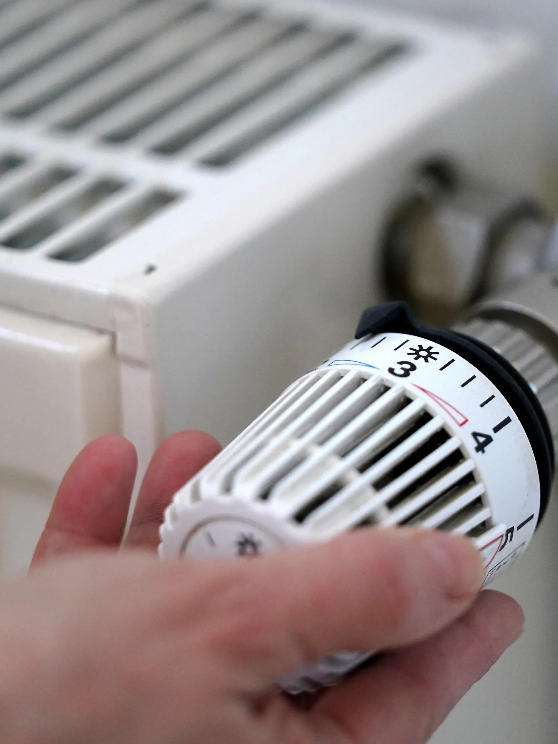 ARCHIV - 09.03.2022, Hamburg: ILLUSTRATION - Eine Frau dreht an einem Heizungsthermostat. (zu dpa: «Vermieter müssen sich an Klimaabgabe fürs Heizen beteiligen») Foto: Marcus Brandt/dpa +++ dpa-Bildfunk +++