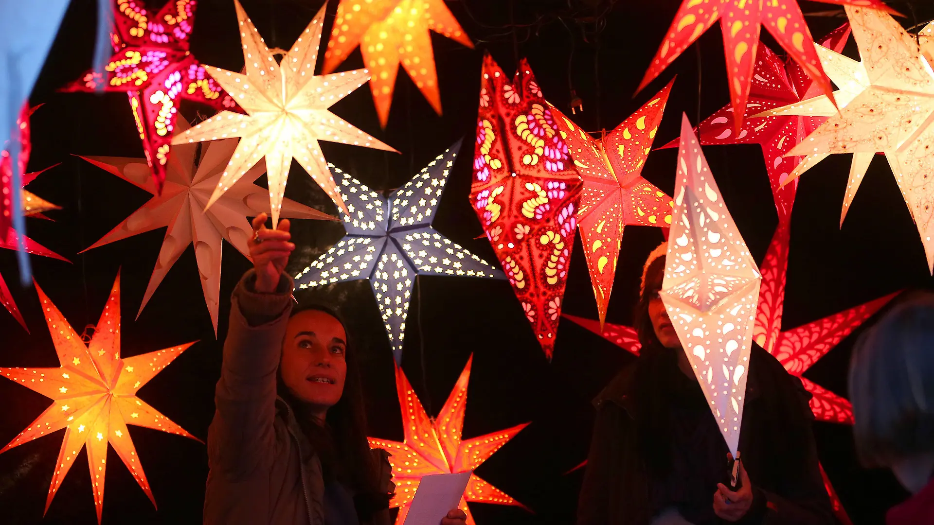 Eine Verkäuferin richtet am 26.11.2012 auf dem Weihnachtsmarkt am Gendarmenmarkt in Berlin Weihnachtssterne aus. Foto: Wolfgang Kumm/dpa +++(c) dpa - Bildfunk+++