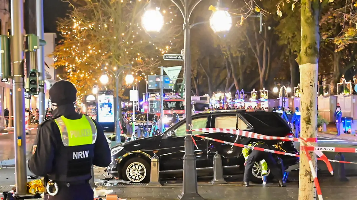 22.11.2022, Nordrhein-Westfalen, Düsseldorf: Flatterband sichert die Unfallstelle rund um ein Auto auf der Königsallee. Auf der Düsseldorfer Einkaufsmeile hat es unweit des Weihnachtsmarktes einen Autounfall mit zwei Schwerverletzten gegeben. Ein 84-Jähriger habe am frühen Dienstagabend die Kontrolle über sein Auto verloren und sei dann in parkende E-Scooter gefahren, sagte ein Polizei-Sprecher. Zwei Fußgänger wurden schwer verletzt, Lebensgefahr bestand den Angaben zufolge bei ihnen aber zufolge nicht. Foto: Alex Forstreuter/dpa +++ dpa-Bildfunk +++