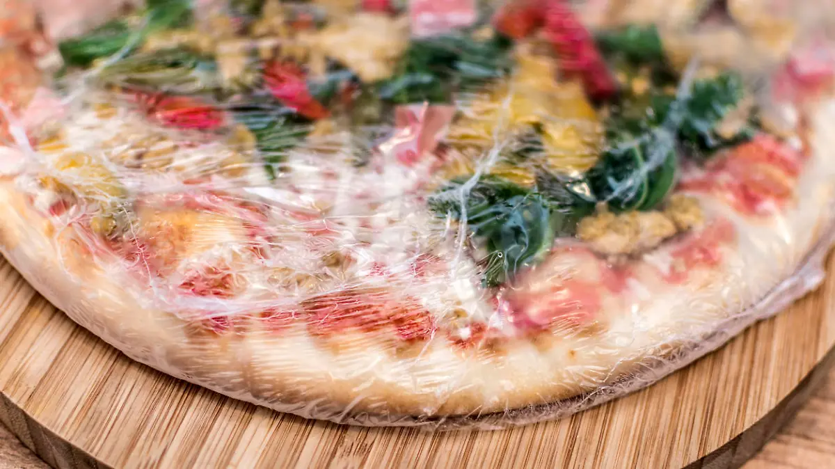 Frozen pizza still in plastic wrap
