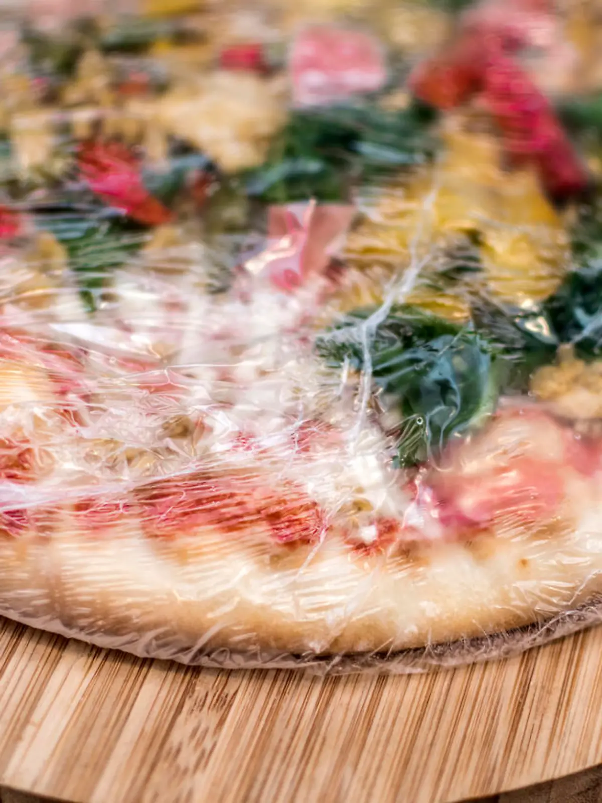 Frozen pizza still in plastic wrap