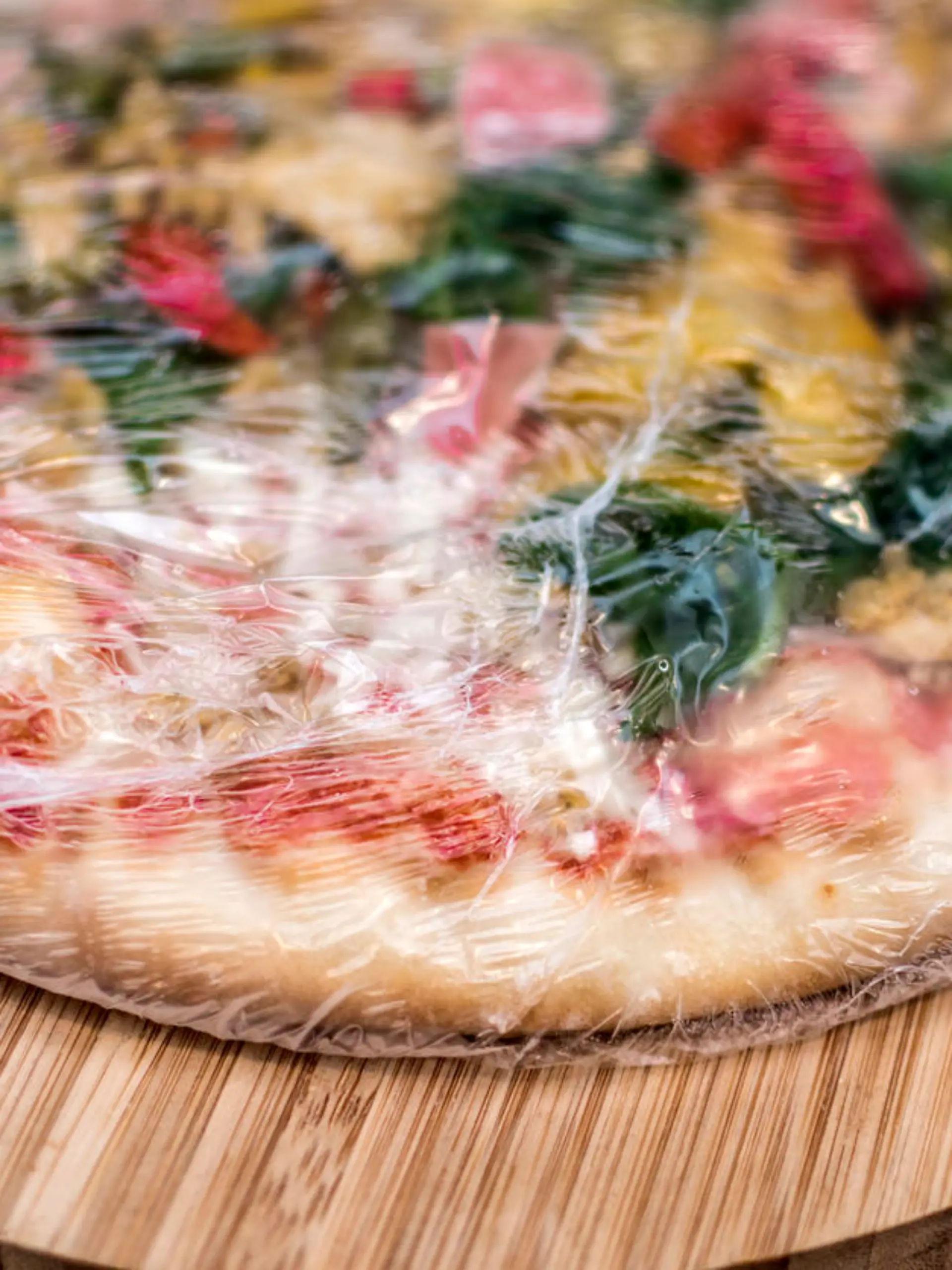 Frozen pizza still in plastic wrap
