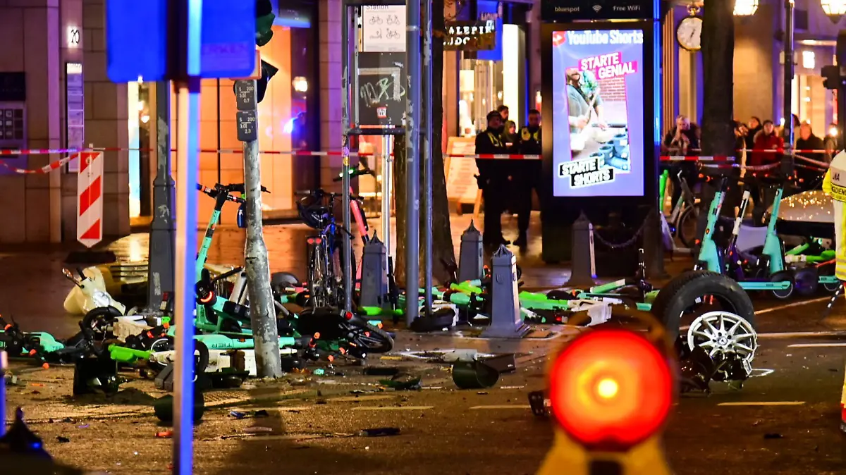 22.11.2022, Nordrhein-Westfalen, Düsseldorf: Flatterband sichert die Unfallstelle rund um stehende und liegende E-Scooter auf der Königsallee. Auf der Düsseldorfer Einkaufsmeile hat es unweit des Weihnachtsmarktes einen Autounfall mit zwei Schwerverletzten gegeben. Ein 84-Jähriger habe am frühen Dienstagabend die Kontrolle über sein Auto verloren und sei dann in parkende E-Scooter gefahren, sagte ein Polizei-Sprecher. Zwei Fußgänger wurden schwer verletzt, Lebensgefahr bestand den Angaben zufolge bei ihnen aber zufolge nicht. Foto: Alex Forstreuter/dpa +++ dpa-Bildfunk +++