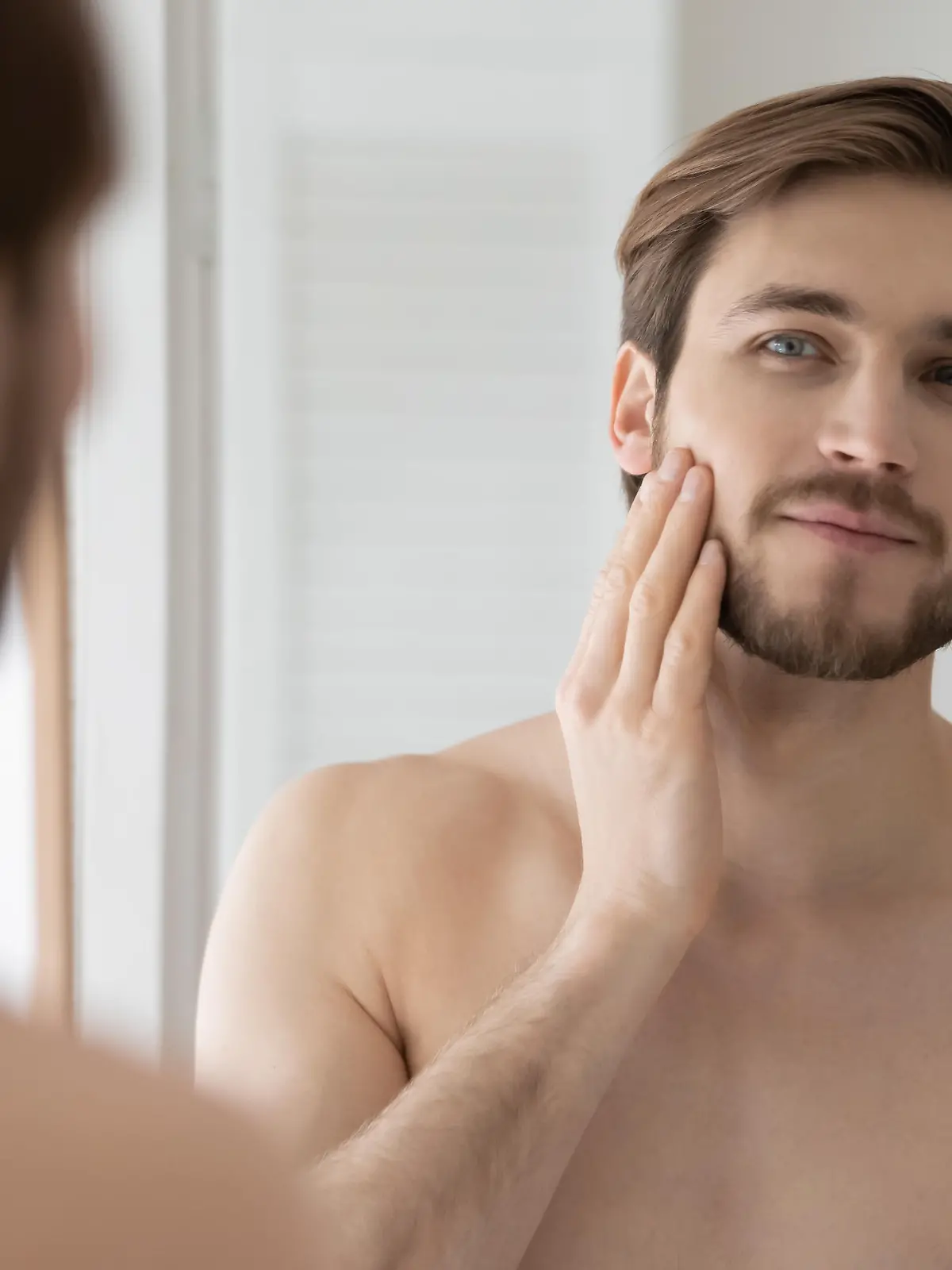 Young  shirtless  man  looking  in  mirror  touch  his  face  after  shave  applied  aftershave  cream  enjoy  smooth,  flawless,  soft  skin.  Grooming,  morning  routine,  ad  of  skincare  cosmetic  products  for  men  concept Model Released Property Released xkwx 30s,  aftershave,  shaving,  anti,  aging,  antiage,  check,  beauty,  care,  clean,  cosmetics,  cream,  bearded,  bathroom,  enjoy,  young,  wrinkle,  touch,  soft,  skin,  skincare,  smooth,  shirtless,  refreshment,  rejuvenation,  reflection,  product,  prevention,  personal,  person,  peeling,  one,  morning,  moisturizer,  mirror,  man,  face,  facial,  fresh,  grooming,  handsome,  health,  healthy,  hydrated,  hygiene,  looking,  lotion,  lifestyle,  dermatology,  routine