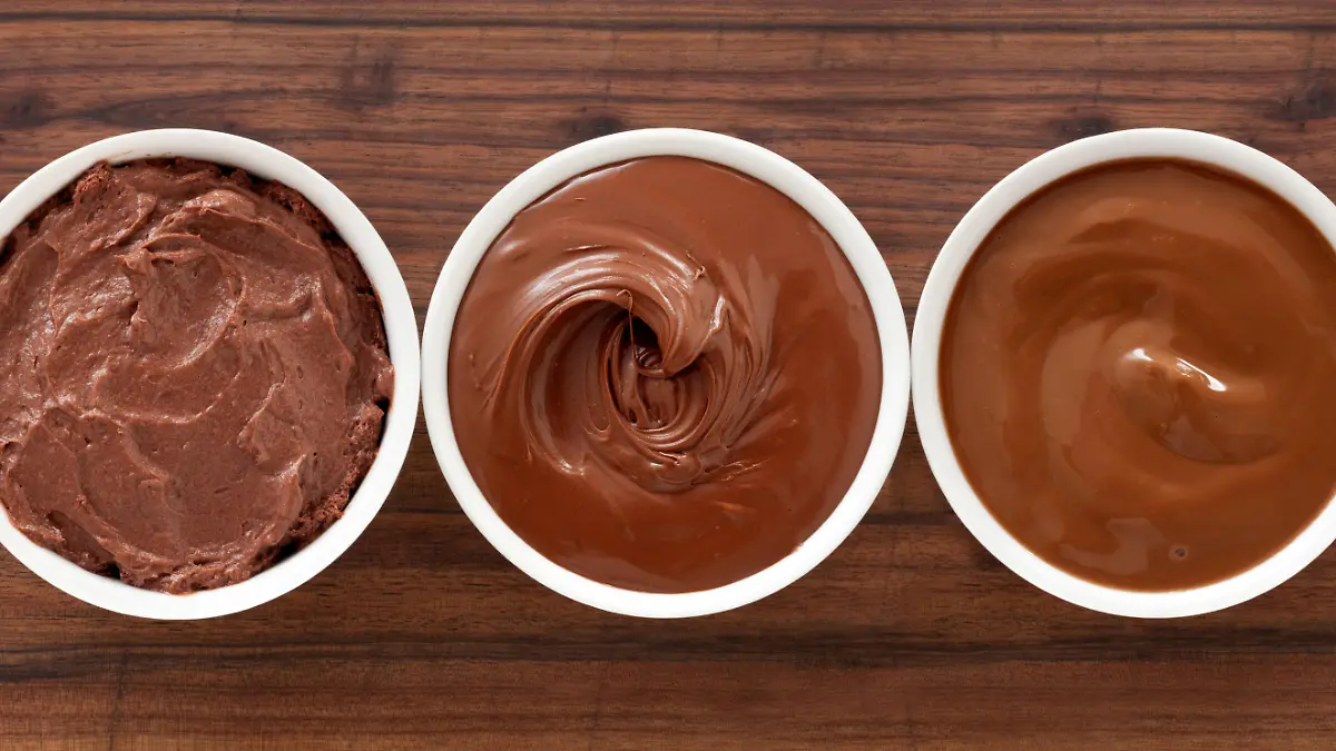 Three bowls containing soft chocolate stuff (mousse, spread and pudding)