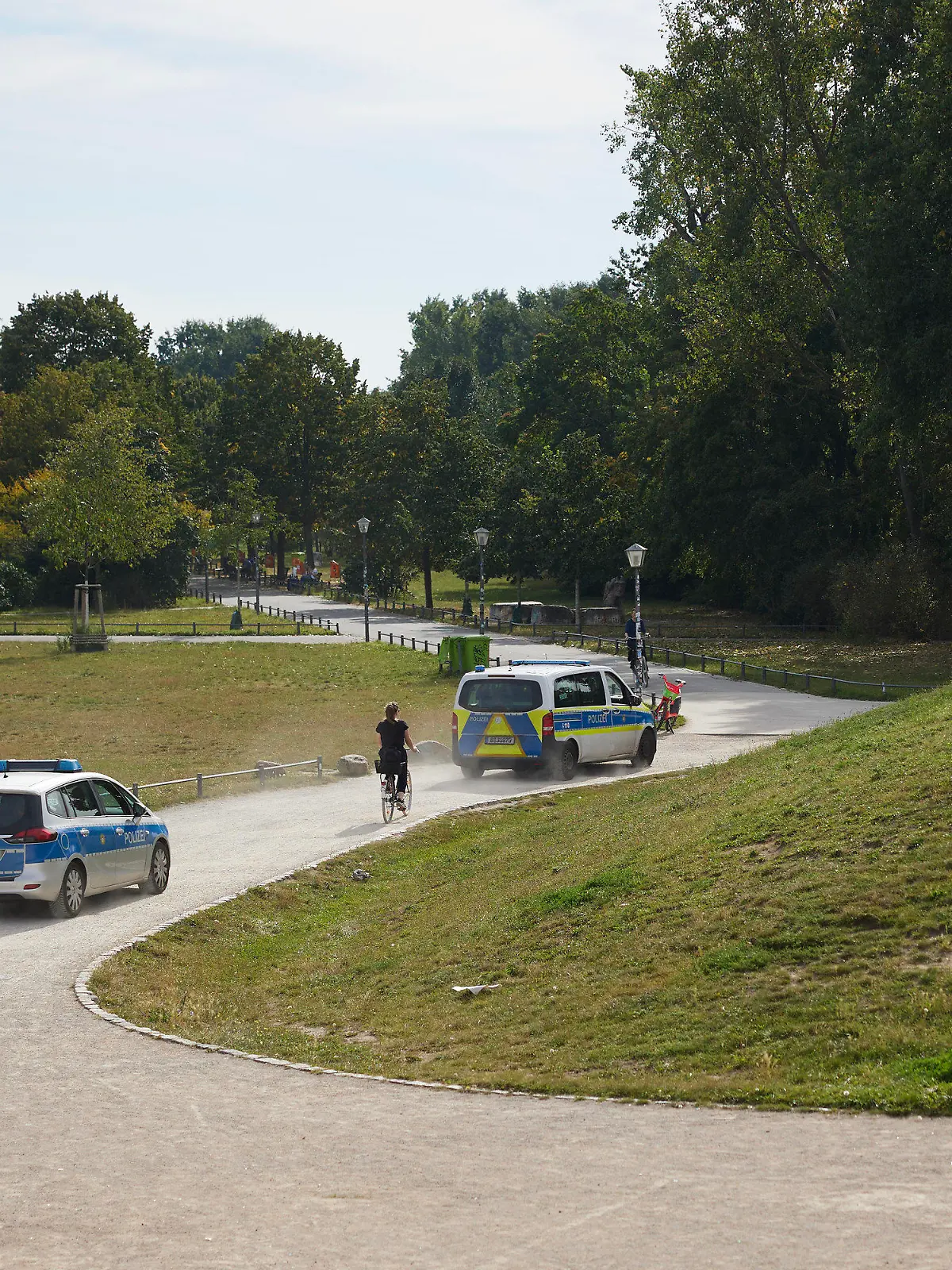 18.09.2023, Berlin: Polizeikräfte fahren durch den Görlitzer Park. Nach dem Willen von Berlins Innensenatorin Spranger soll die bestehende Mauer um den Görlitzer Park in Kreuzberg komplett abgerissen werden, um die Sicherheit zu erhöhen. Das Bauwerk biete Dealern und anderen Kriminellen einen Sichtschutz, der sie zu Straftaten verführen könnte, argumentiert die SPD-Politikerin nach einem Bericht der «Berliner Morgenpost». Foto: Jörg Carstensen/dpa +++ dpa-Bildfunk +++