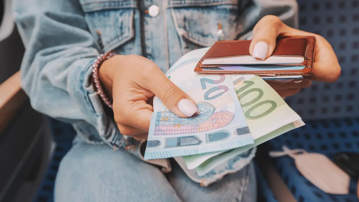 The girl takes euro banknotes out of her wallet. The concept of devaluation and inflation of the European currency