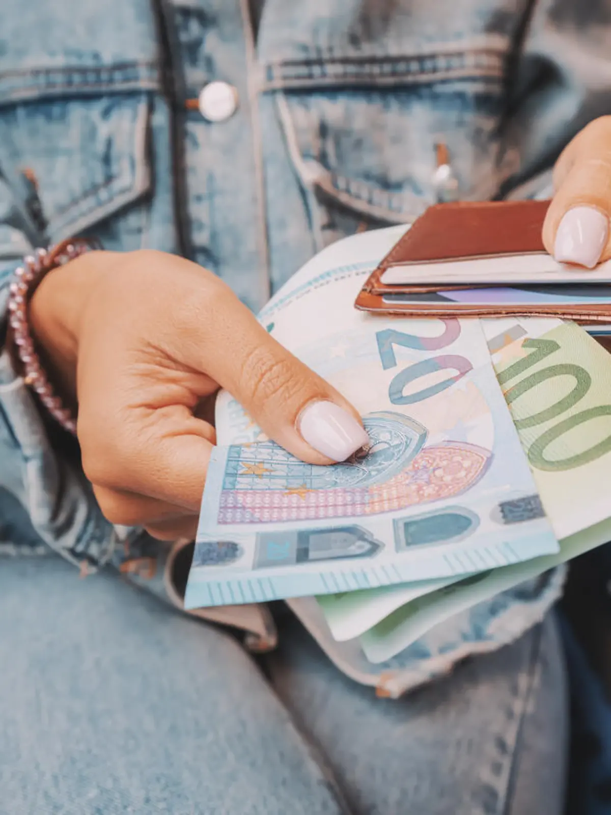 The girl takes euro banknotes out of her wallet. The concept of devaluation and inflation of the European currency