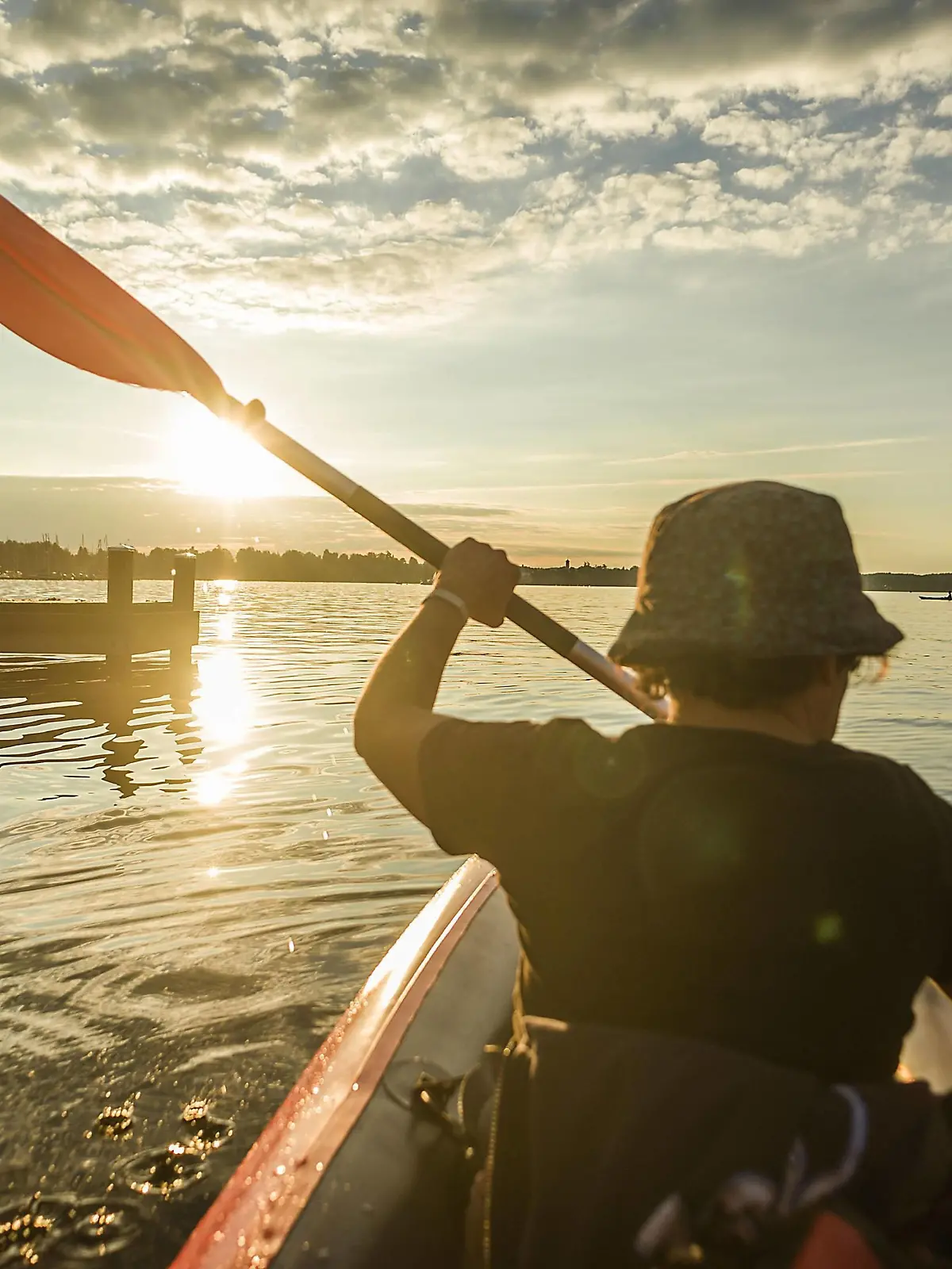  Eine Frau fährt mit ihrem Kajak auf dem Starnberger See dem Sonnenuntergang entgegenan, Starnberg, Bayern, Deutschland. Eine Frau paddelt auf einer Kajaktour auf dem Starnberger See