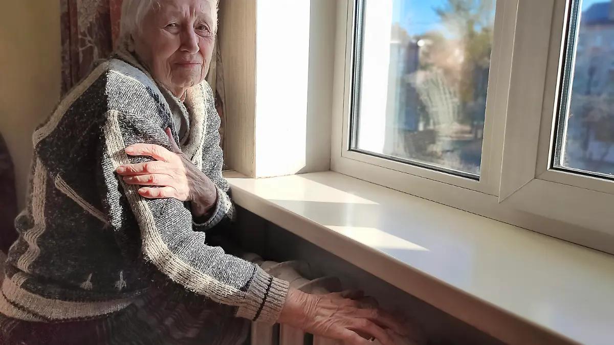 Freezing old people in Europe. The senior woman in bed at home. Payment for heating in winter. The gas crisis has led to an increase in gas prices