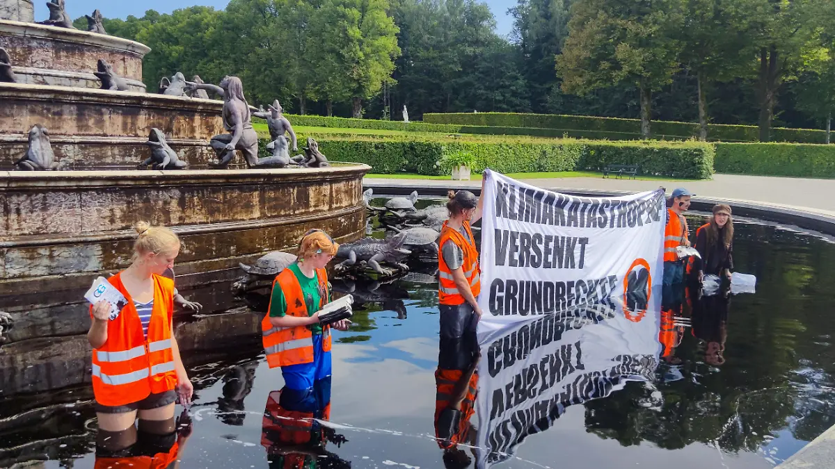 Aktivisten der Letzten Generation stehen bei der Protestaktion am 23. August im Wasser des Latona-Brunnens in Herrenchiemsee.