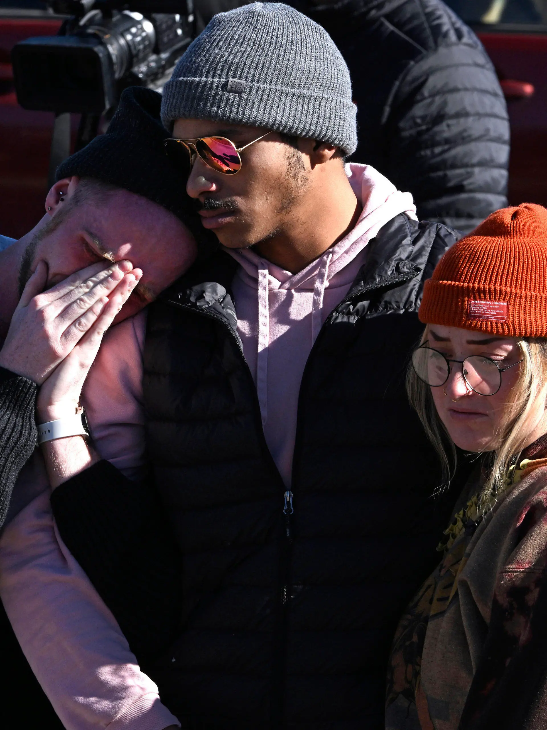 Tyler Johnston, left, his fiance Keenan Mestas-Holmes, center, and their friend Atlas Pretzeus hug one another while paying their respects at a makeshift memorial near Club Q on Sunday, Nov. 20, 2022 in Colorado Springs, Colo. The trio have close friends that were involved in the shooting. An attacker opened fire in a gay nightclub late Saturday night. (Helen H. Richardson/The Denver Post via AP)