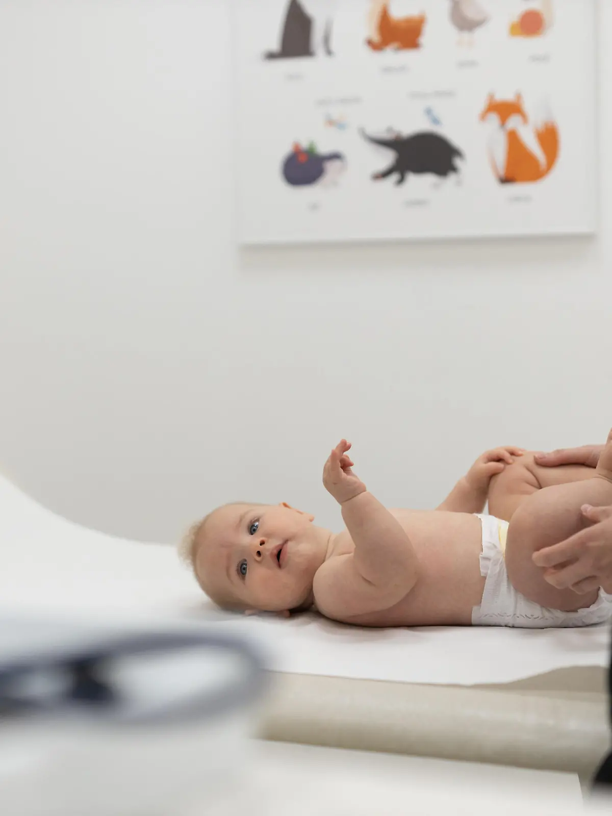 Baby lying on his back during a standard medical checkup at pediatrician. || Modellfreigabe vorhanden