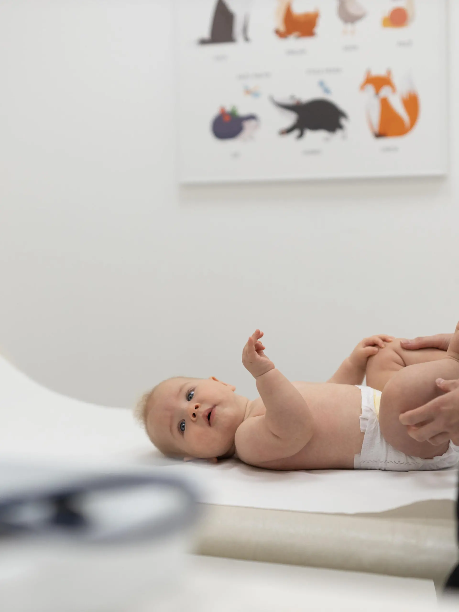 Baby lying on his back during a standard medical checkup at pediatrician. || Modellfreigabe vorhanden