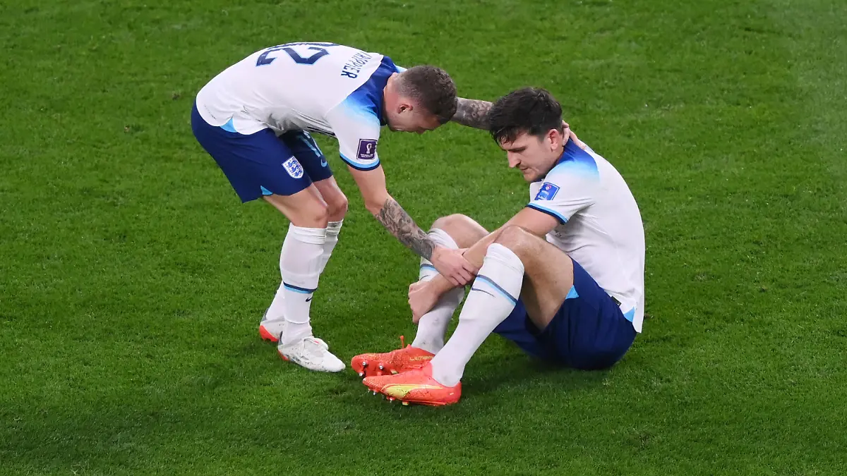 DOHA, QATAR - NOVEMBER 21: Harry Maguire of England is attended to by Kieran Trippier before being substituted off during the FIFA World Cup Qatar 2022 Group B match between England and IR Iran at Khalifa International Stadium on November 21, 2022 in Doha, Qatar. (Photo by Laurence Griffiths/Getty Images)