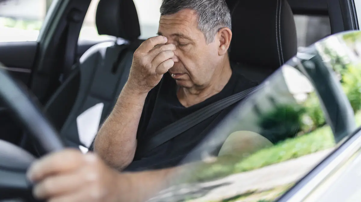 Tired pensioner in his 70s, dring in a car