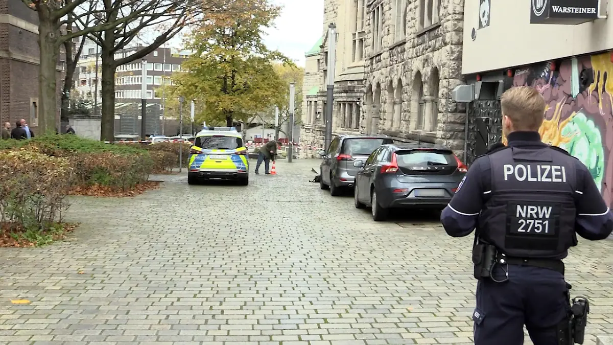 18.11.2022, Nordrhein-Westfalen, Essen: Einsatzkräfte der Polizei stehen am Rabbinerhaus bei der Alten Synagoge. Am Rabbinerhaus bei der Alten Synagoge in Essen sind Einschusslöcher gefunden worden. Es bestehe keine Gefahr, niemand sei verletzt, sagte eine Polizeisprecherin am Freitag. Es sei aber ein Sprengstoffspürhund im Einsatz, man habe zu dem Fall eine Ermittlungskommission eingesetzt. (zu dpa «Einschusslöcher bei Synagoge in Essen entdeckt») Foto: Justin Brosch/ANC-NEWS/dpa - ACHTUNG: Kennzeichen wurde(n) aus rechtlichen Gründen gepixelt +++ dpa-Bildfunk +++