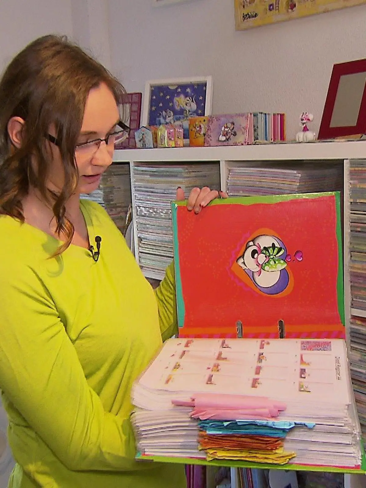 Sandra Muschner steht vor ihrer Diddl-Wand und zeigt ihre besondere Sammlung.