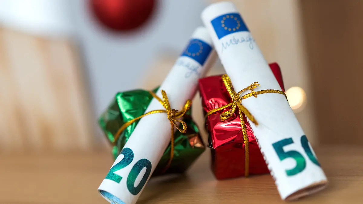 ILLUSTRATION - 04.12.2018, Sachsen, Dresden: ARCHIV - Als Geschenk verpackte 20 und 50 Euro Banknoten liegen auf einem Tisch. Weihnachten steht vor der Tür und damit auch der Stress, die richtigen Geschenke zu finden. Noch beliebter als liebevoll ausgesuchte Überraschungen scheinen nur Geldgeschenke zu sein. 2019 wollte mehr als jeder zweite Verbraucher (56 Prozent) auf diese Weise der Gefahr entgehen, beim Kauf danebenzugreifen. (zu dpa "Die Psychologie des Schenkens - «Geld geht immer") Foto: Monika Skolimowska/dpa-Zentralbild/dpa +++ dpa-Bildfunk +++