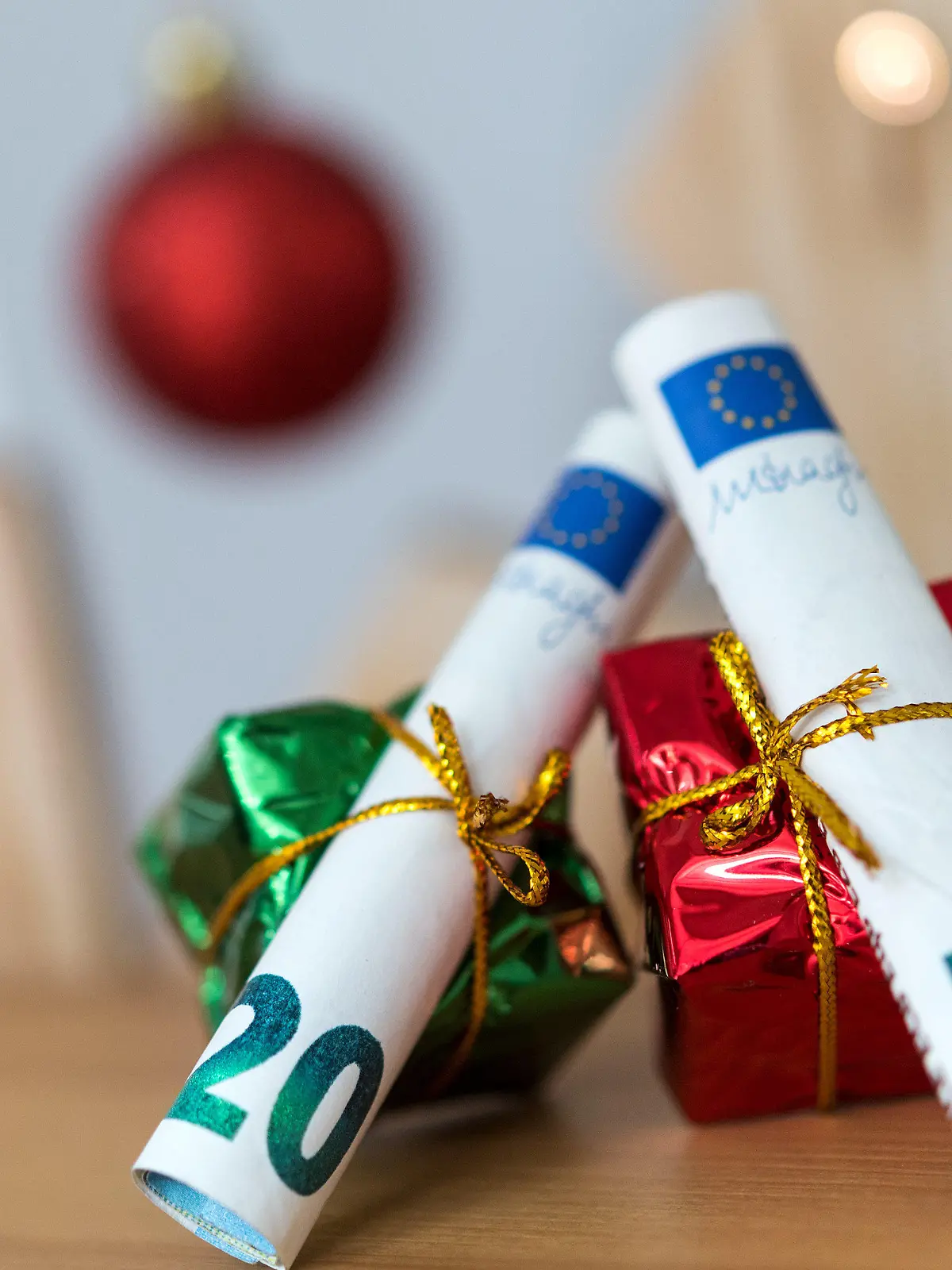 ILLUSTRATION - 04.12.2018, Sachsen, Dresden: ARCHIV - Als Geschenk verpackte 20 und 50 Euro Banknoten liegen auf einem Tisch.  Weihnachten steht vor der Tür und damit auch der Stress, die richtigen Geschenke zu finden. Noch beliebter als liebevoll ausgesuchte Überraschungen scheinen nur Geldgeschenke zu sein. 2019 wollte mehr als jeder zweite Verbraucher (56 Prozent) auf diese Weise der Gefahr entgehen, beim Kauf danebenzugreifen. (zu dpa "Die Psychologie des Schenkens - «Geld geht immer") Foto: Monika Skolimowska/dpa-Zentralbild/dpa +++ dpa-Bildfunk +++