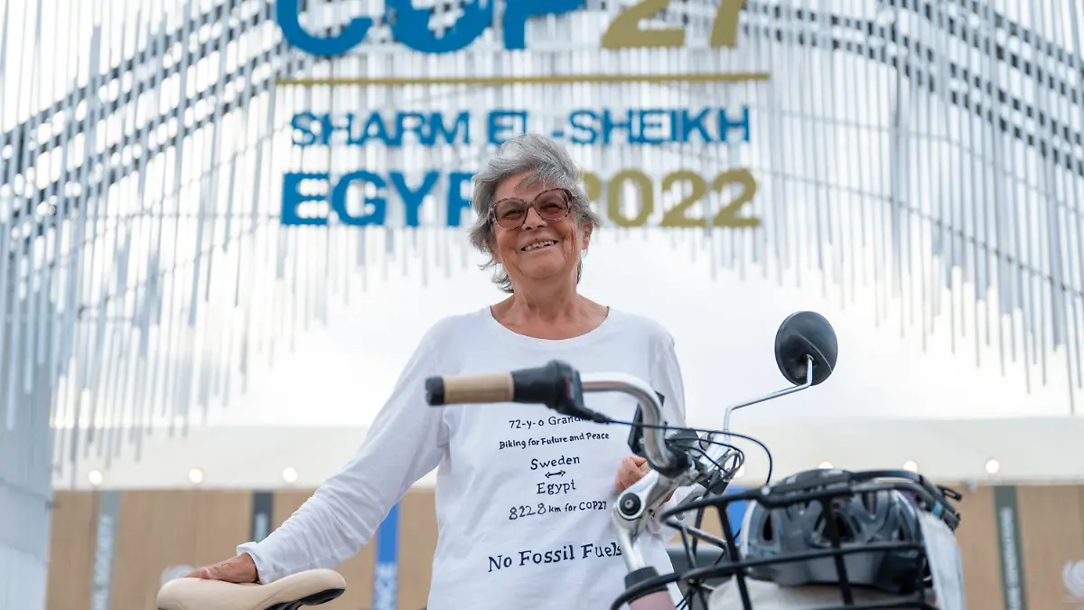 14.11.2022, Ägypten, Scharm El Scheich: Dorothee Hildebrandt steht mit ihrem Fahrrad vor dem Eingang vom UN-Klimagipfel COP27. Die 72-Jährige ist mit ihrem Fahrrad von Schweden aus 8228 km bis zur COP27 gefahren. Foto: Christophe Gateau/dpa +++ dpa-Bildfunk +++