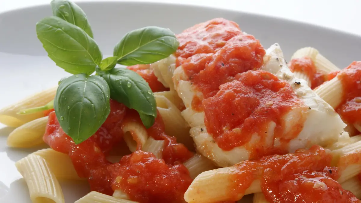Gekochte Dorschstücke mit Nudeln und Tomatensoße