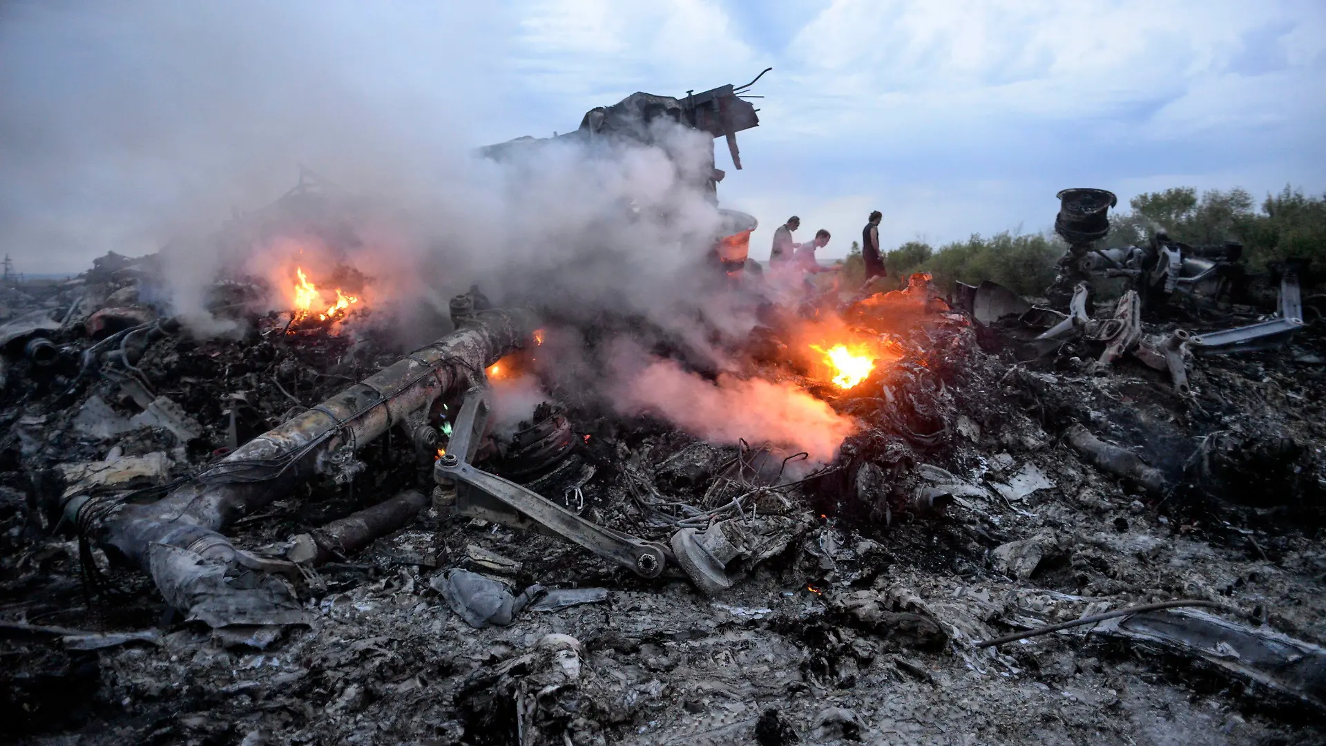 ARCHIV - 16.07.2014, Ukraine, Donezk: Brennende Trümmer einer Boeing 777 der Malaysia Airlines liegen nahe Donezk in der östlichen Ukraine. Das Passagierflugzeug mit der Flugnummer MH17 war mit 283 Passagieren und 15 Crewmitgliedern an Bord abgeschossen worden. (zu "Internationale Ermittler: Neue Beweise zum Abschuss von Flug MH17") Foto: Alyona Zykina/epa/dpa +++ dpa-Bildfunk +++