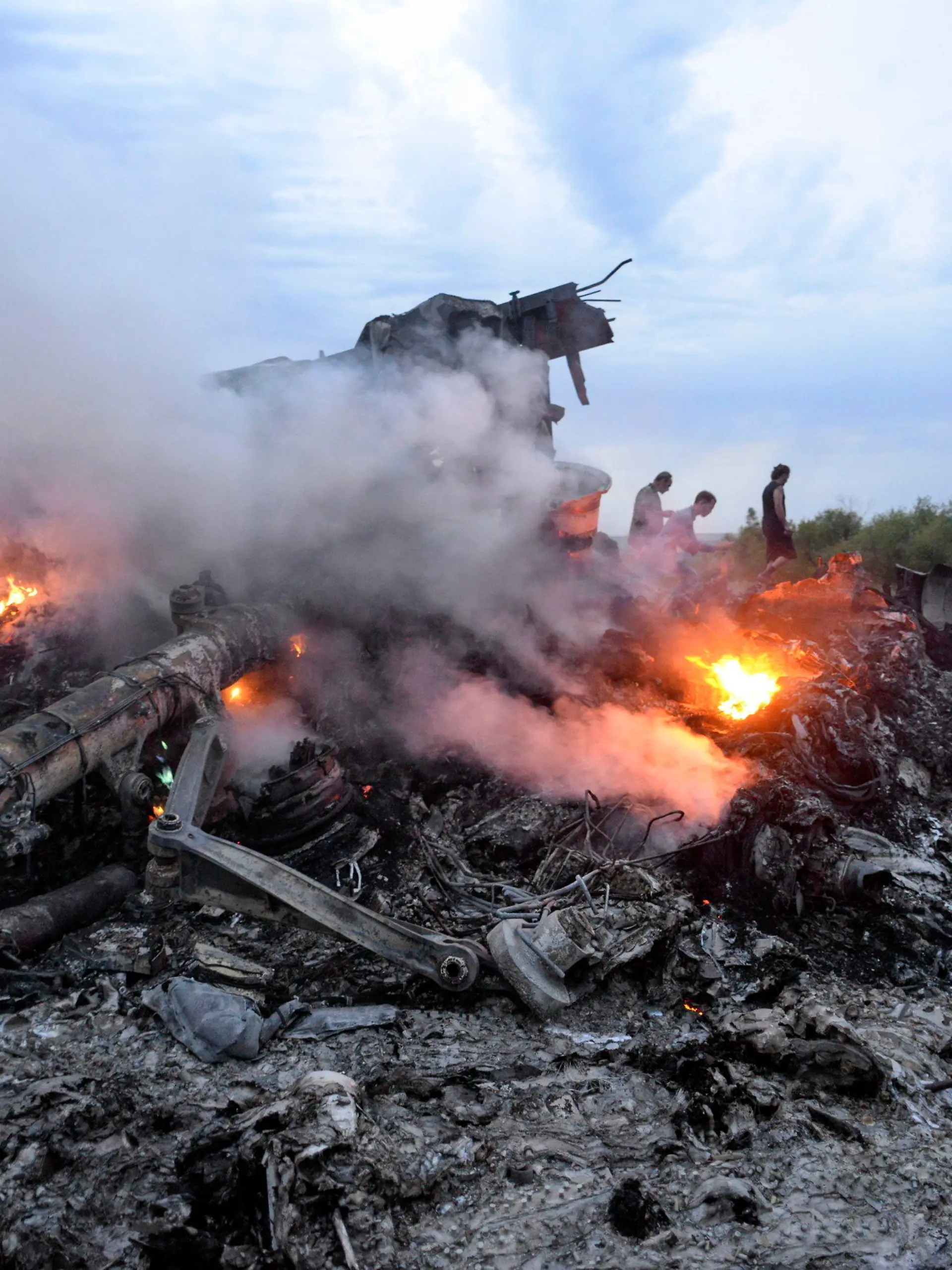 ARCHIV - 16.07.2014, Ukraine, Donezk: Brennende Trümmer einer Boeing 777 der Malaysia Airlines liegen nahe Donezk in der östlichen Ukraine. Das Passagierflugzeug mit der Flugnummer MH17 war mit 283 Passagieren und 15 Crewmitgliedern an Bord abgeschossen worden.   (zu "Internationale Ermittler: Neue Beweise zum Abschuss von Flug MH17") Foto: Alyona Zykina/epa/dpa +++ dpa-Bildfunk +++