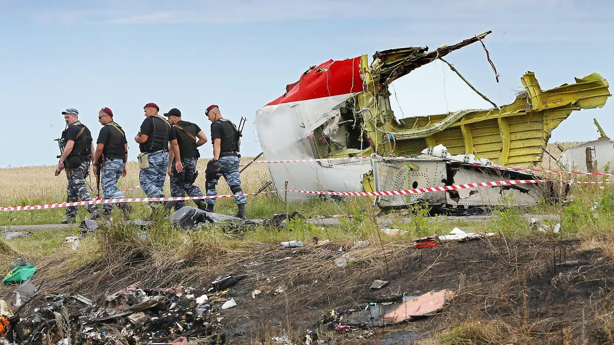 ARCHIV - 20.07.2014, Ukraine, Donezk: Bewaffnete Separatisten passieren ein großes Trümmerstück an der Absturzstelle der Boeing 777, die als Flug MH17 der Malaysia Airlines, beim Überfliegen der Ukraine, etwa 100 km östlich von Donezk, abstürzte. Mehr als acht Jahre nach dem Abschuss des Passagierfluges MH17 mit 298 Toten soll das Urteil gegen die vier mutmaßlichen Hauptverantwortlichen verkündet werden. Die damals hochrangigen prorussischen Separatisten sind der Anklage zufolge verantwortlich, dass die Maschine der Malaysia Airlines am 17. Juli 2014 auf dem Weg von Amsterdam nach Kuala Lumpur mit einer russischen Luftabwehrrakete vom Typ Buk abgeschossen wurde. Foto: Robert Ghement/EPA/dpa +++ dpa-Bildfunk +++