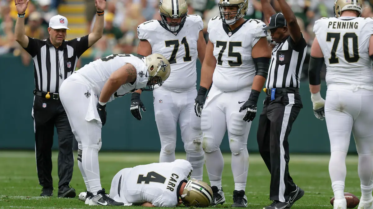 New Orleans Saints quarterback Derek Carr (4) lays on the turf after being hurt while being sacked during the second half of an NFL football game against the Green Bay Packers Sunday, Sept. 24, 2023, in Green Bay, Wis. (AP Photo/Matt Ludtke)