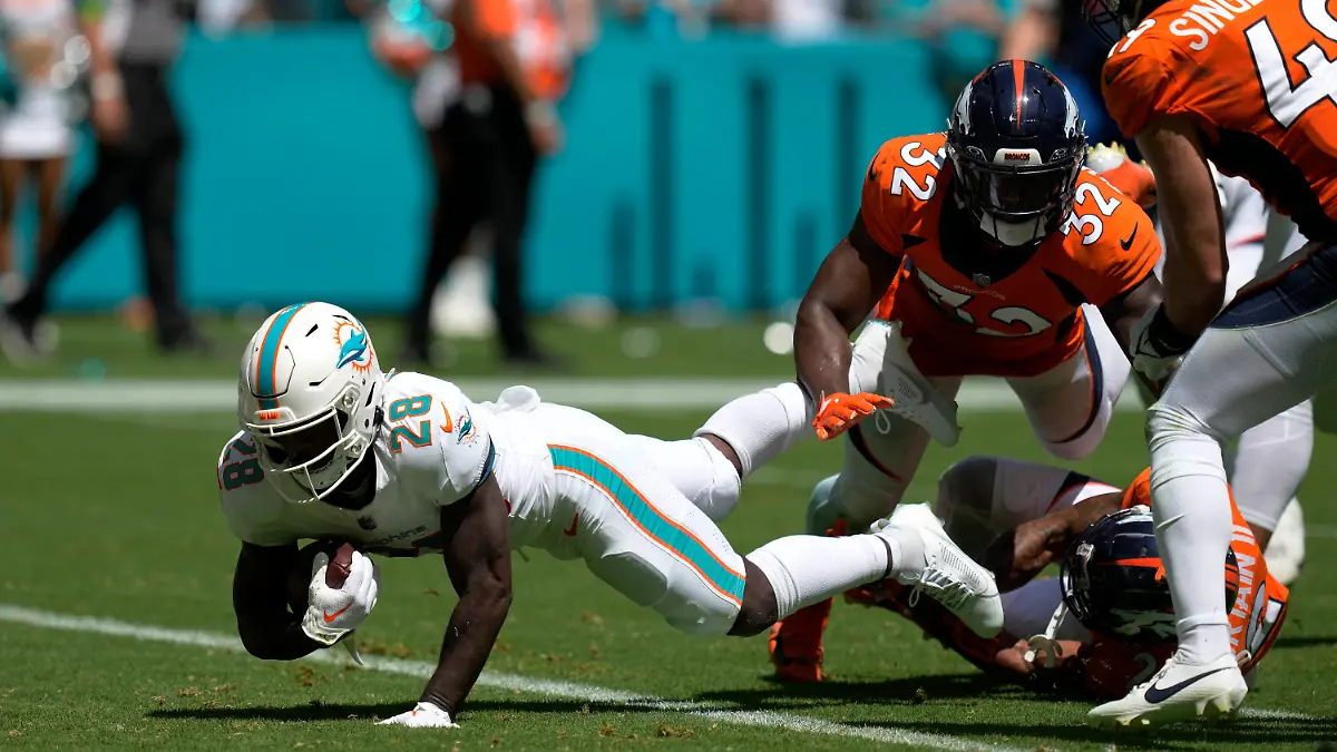 24.09.2023, USA, Miami Gardens: American Football: Profiliga NFL, Hauptrunde, Hauptrunde-Partien, 3. Spieltag, Miami Dolphins - Denver Broncos. De'Von Achane (l) von den Miami Dolphins erzielt einen Touchdown. Foto: Rebecca Blackwell/AP/dpa +++ dpa-Bildfunk +++