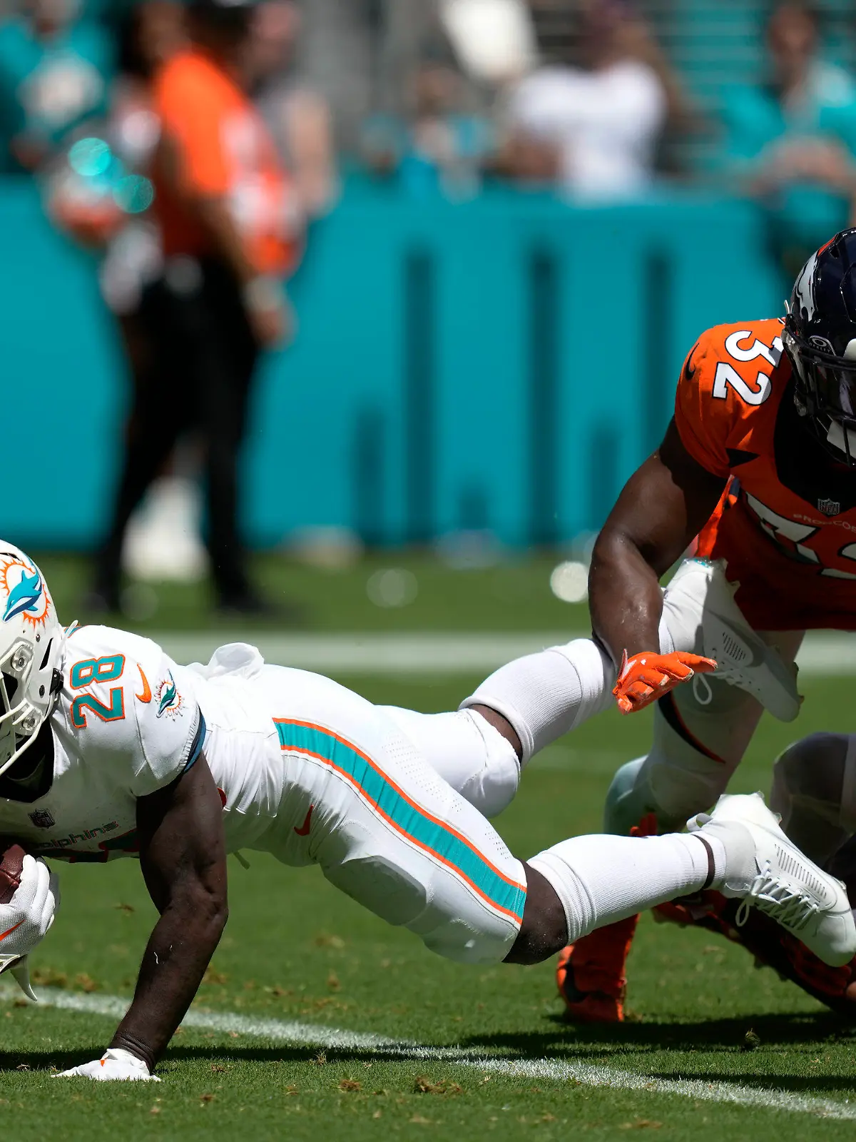 24.09.2023, USA, Miami Gardens: American Football: Profiliga NFL, Hauptrunde, Hauptrunde-Partien, 3. Spieltag, Miami Dolphins - Denver Broncos. De'Von Achane (l) von den Miami Dolphins erzielt einen Touchdown. Foto: Rebecca Blackwell/AP/dpa +++ dpa-Bildfunk +++