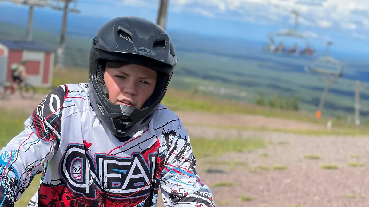 Benjamin sitzt auf einem BMX und trägt einen Schutzhelm.