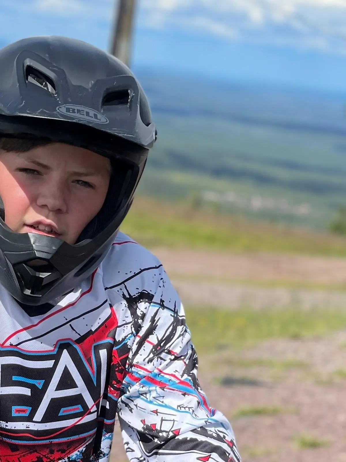 Benjamin sitzt auf einem BMX und trägt einen Schutzhelm.