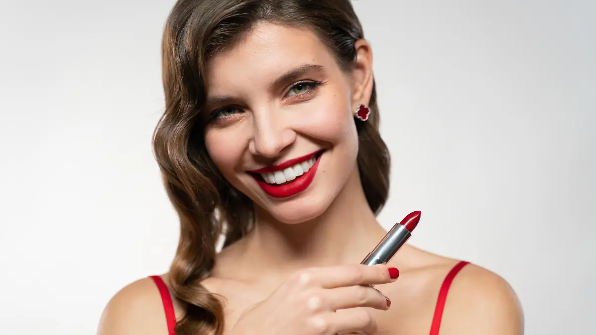 Frau, die mit einem roten Lippenstift posiert.