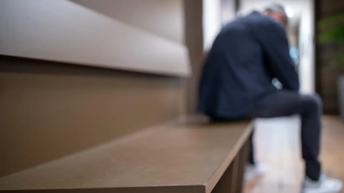 ARCHIV - 14.05.2020, Bayern, Nürnberg: ILLUSTRATION - Ein Mann sitzt mit gesenktem Kopf auf einer Bank. Krieg, Corona, Inflation: Im aktuellen Krisenumfeld schießen esoterische und sektenartige Beratungsangebote in Deutschland wie Pilze aus dem Boden. Beratungsstellen berichten bundesweit von steigenden Anfragezahlen und hoher Auslastung. (zu dpa «Amulett und Psycho-Coach: Menschen flüchten vor Krise in Esoterik») Foto: Daniel Karmann/dpa +++ dpa-Bildfunk +++