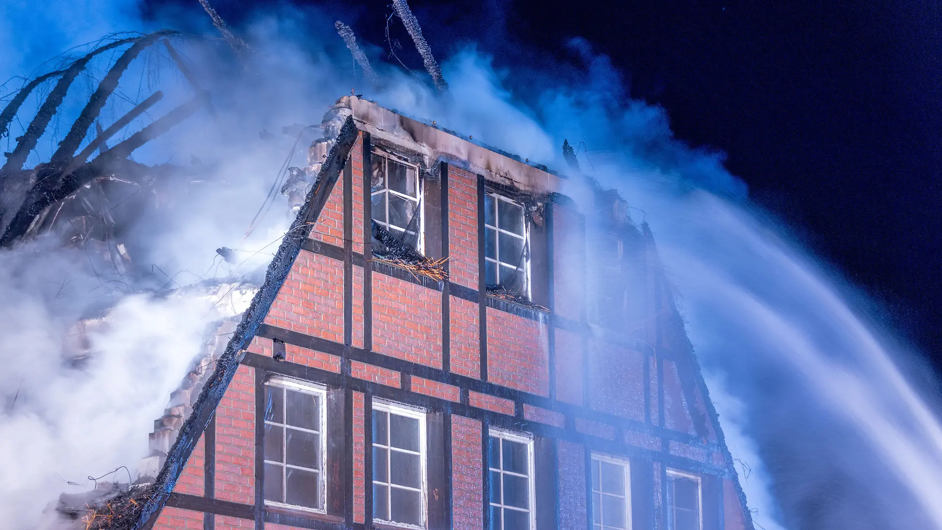 20.10.2022, Mecklenburg-Vorpommern, Groß Strömkendorf: Feuerwehrleute löschen den Brand in einem Hotel in dem Geflüchtete aus der Ukraine untergebracht waren. Durch einen Brand ist eine Unterkunft für Geflüchtete aus der Ukraine in der Gemeinde Groß Strömkendorf in Mecklenburg-Vorpommern in der Nacht zu Donnerstag fast vollständig zerstört worden. Verletzt wurde bei dem Feuer niemand. Die Polizei geht eigenen Angaben zufolge von Brandstiftung aus. Noch am Tage des Brandes hatte die Polizei die Unterkunft - ein Hotel - wegen einer Hakenkreuz-Schmiererei auf dem Eingangsschild aufgesucht, wie Landrat Tino mitteilte. Foto: Jens Büttner/dpa +++ dpa-Bildfunk +++