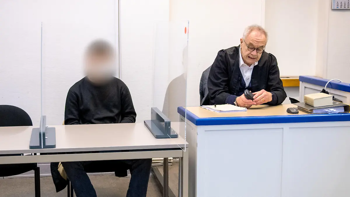 16.11.2022, Hamburg: Ein 22 Jahre alter Angeklagter (l.) sitzt im Amtsgericht Harburg im Saal neben seinem Anwalt Siegfried Schäfer. Der Mann soll auf einer Party im Stadtteil Winterhude einem 16-jährigen Mädchen zwei Ecstasy-Tabletten gegeben haben, das Mädchen starb kurz danach an einer von den Drogen ausgelösten Hyperthermie (Überwärmung). Foto: Daniel Bockwoldt/dpa - ACHTUNG: Person wurde aus rechtlichen Gründen gepixelt +++ dpa-Bildfunk +++
