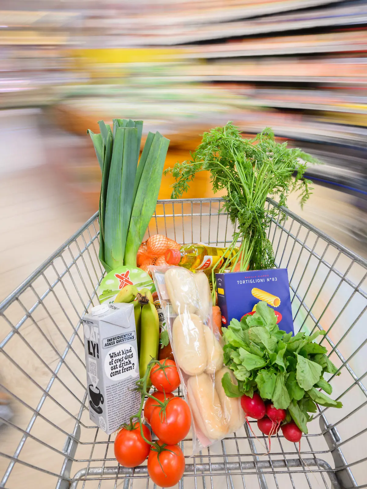 ARCHIV - 30.08.2023, Niedersachsen, Hannover: ILLUSTRATION - Ein mit Lebensmittel gefüllter Einkaufswagen wird durch einen Supermarkt geschoben (gestellte Szene, Aufnahme mit langer Verschlusszeit). (Zu dpa "Einkäufe für Verbraucher teurer, reale Umsätze für Händler rückläufig") Foto: Julian Stratenschulte/dpa +++ dpa-Bildfunk +++