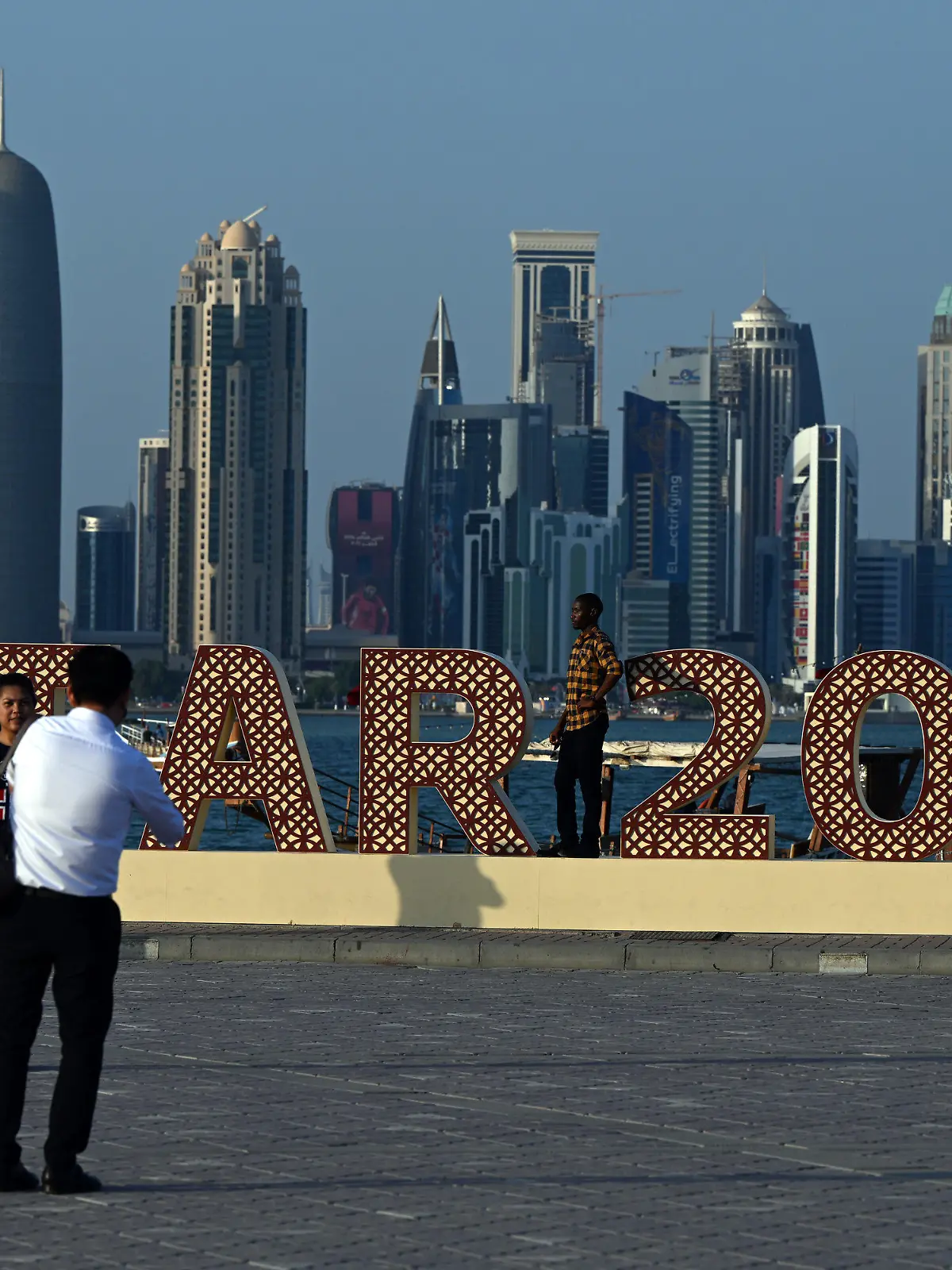 15.11.2022, Katar, Doha: Touristen fotografieren sich vor dem Schriftzug "Qatar 2022". Mit dem Eröffnungsspiel Katar gegen Ecuador beginnt am 20.11.2022 die Fußball-WM 2022. Foto: Federico Gambarini/dpa +++ dpa-Bildfunk +++