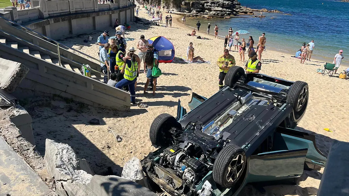 25.09.2023, Australien, Sydney: Ein Auto liegt auf dem Dach am Strand von Balmoral Beach. Eine australische Fahranfängerin wollte in Sydney das Einparken üben - und ist mit ihrem Auto mit voller Wucht auf einem belebten Strand gelandet. Die 33-Jährige, die in Begleitung eines 55-jährigen Beifahrers war, sei am Montag mit dem Wagen gegen einen Bordstein geprallt und habe dann in Panik Gas gegeben, berichtete der Sender 9News unter Berufung auf die Polizei. Dabei habe das Fahrzeug eine Mauer durchbrochen und sei dann auf dem Dach am beliebten Balmoral Beach im Stadtteil Mosman gelandet. Foto: Rachel Chappell/North Shore Mums/dpa - ACHTUNG: Nur zur redaktionellen Verwendung im Zusammenhang mit der aktuellen Berichterstattung und nur mit vollständiger Nennung des vorstehenden Credits +++ dpa-Bildfunk +++