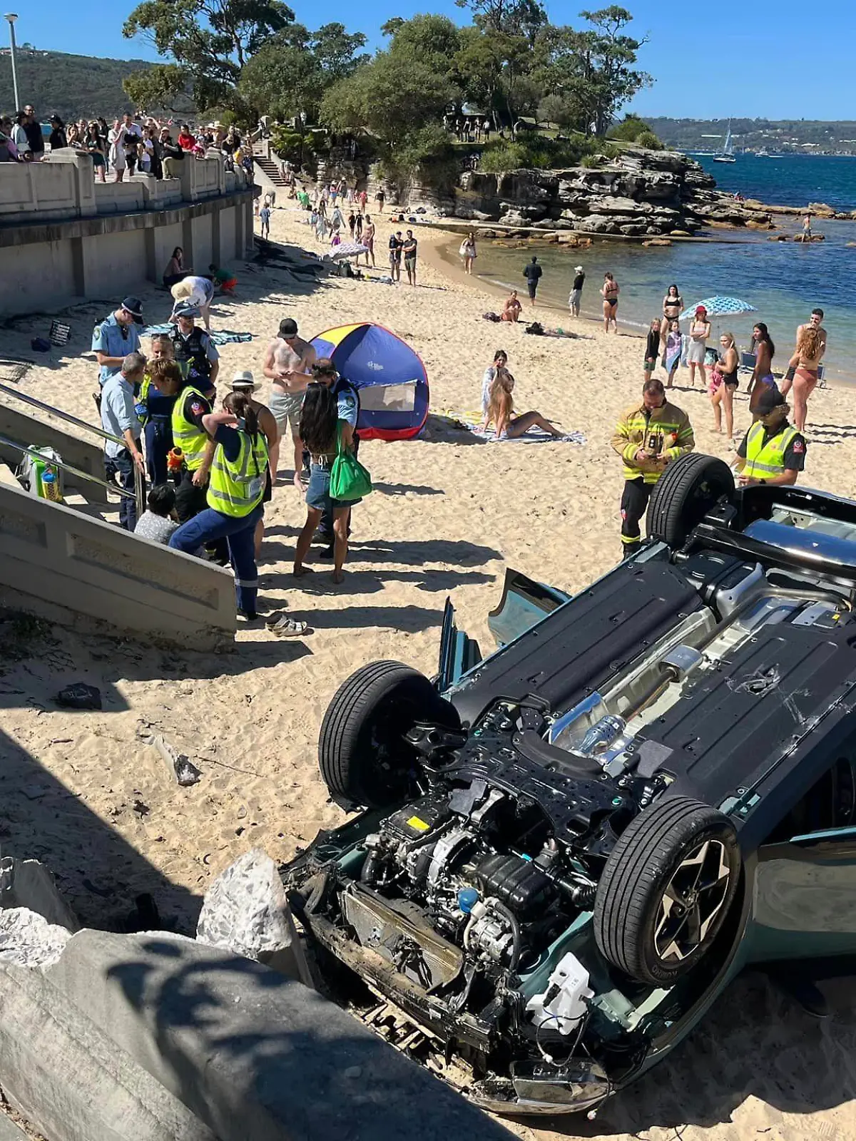 25.09.2023, Australien, Sydney: Ein Auto liegt auf dem Dach am Strand von Balmoral Beach. Eine australische Fahranfängerin wollte in Sydney das Einparken üben - und ist mit ihrem Auto mit voller Wucht auf einem belebten Strand gelandet. Die 33-Jährige, die in Begleitung eines 55-jährigen Beifahrers war, sei am Montag mit dem Wagen gegen einen Bordstein geprallt und habe dann in Panik Gas gegeben, berichtete der Sender 9News unter Berufung auf die Polizei. Dabei habe das Fahrzeug eine Mauer durchbrochen und sei dann auf dem Dach am beliebten Balmoral Beach im Stadtteil Mosman gelandet. Foto: Rachel Chappell/North Shore Mums/dpa - ACHTUNG: Nur zur redaktionellen Verwendung im Zusammenhang mit der aktuellen Berichterstattung und nur mit vollständiger Nennung des vorstehenden Credits +++ dpa-Bildfunk +++