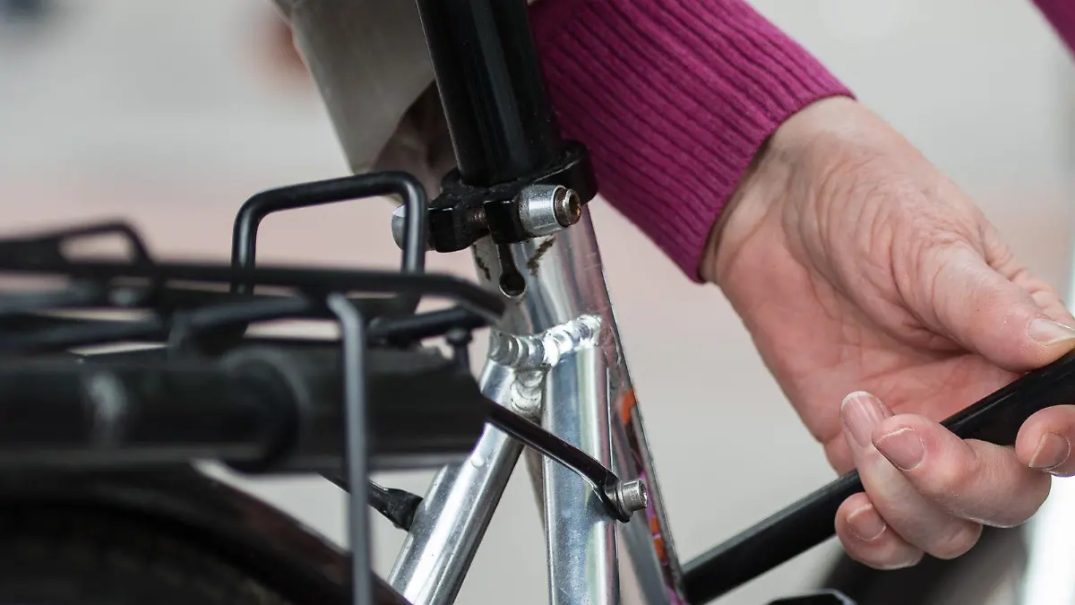 Eine Frau schließt am 03.05.2017 in einer Fußgängerzone in Hannover (Niedersachsen) ein Fahrrad mit einem Fahrradschloss an einen Metallbügel an. (zu dpa "Weniger Fahrradiebstähle in Niedersachsen" vom 05.05.2017) Foto: Silas Stein/dpa +++(c) dpa - Bildfunk+++