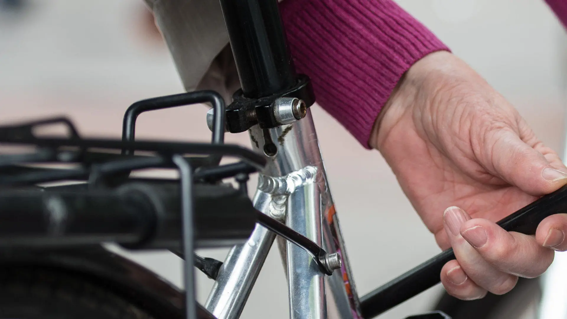 Eine Frau schließt am 03.05.2017 in einer Fußgängerzone in Hannover (Niedersachsen) ein Fahrrad mit einem Fahrradschloss an einen Metallbügel an. (zu dpa "Weniger Fahrradiebstähle in Niedersachsen" vom 05.05.2017) Foto: Silas Stein/dpa +++(c) dpa - Bildfunk+++