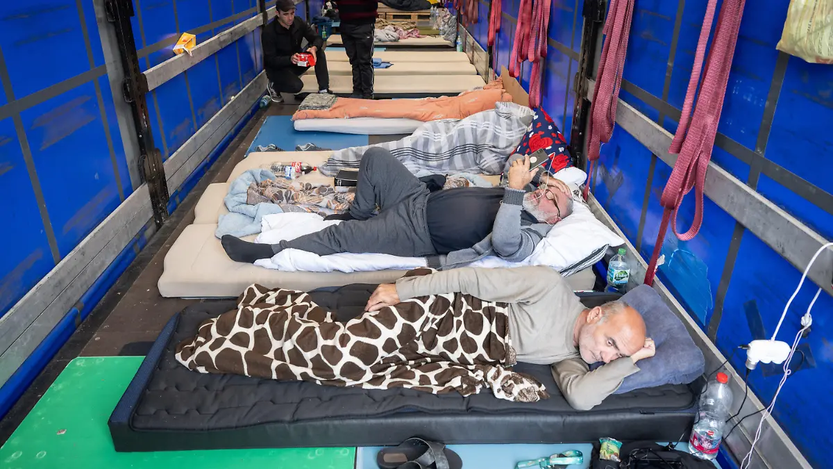 22.09.2023, Hessen, Gräfenhausen: Trucker aus Georgien liegen auf einem Matratzenlager auf der Ladefläche eines Lastkraftwagens. Um ihrer Forderung nach der Auszahlung nicht gezahlter Gehälter ihres polnischen Spediteurs Nachdruck zu verleihen sind rund 30 Fahrer in einen Hungerstreik getreten. Die LKW-Fahrer harren bereits seit Monaten auf der Raststätte Gräfenhausen aus. Foto: Boris Roessler/dpa +++ dpa-Bildfunk +++