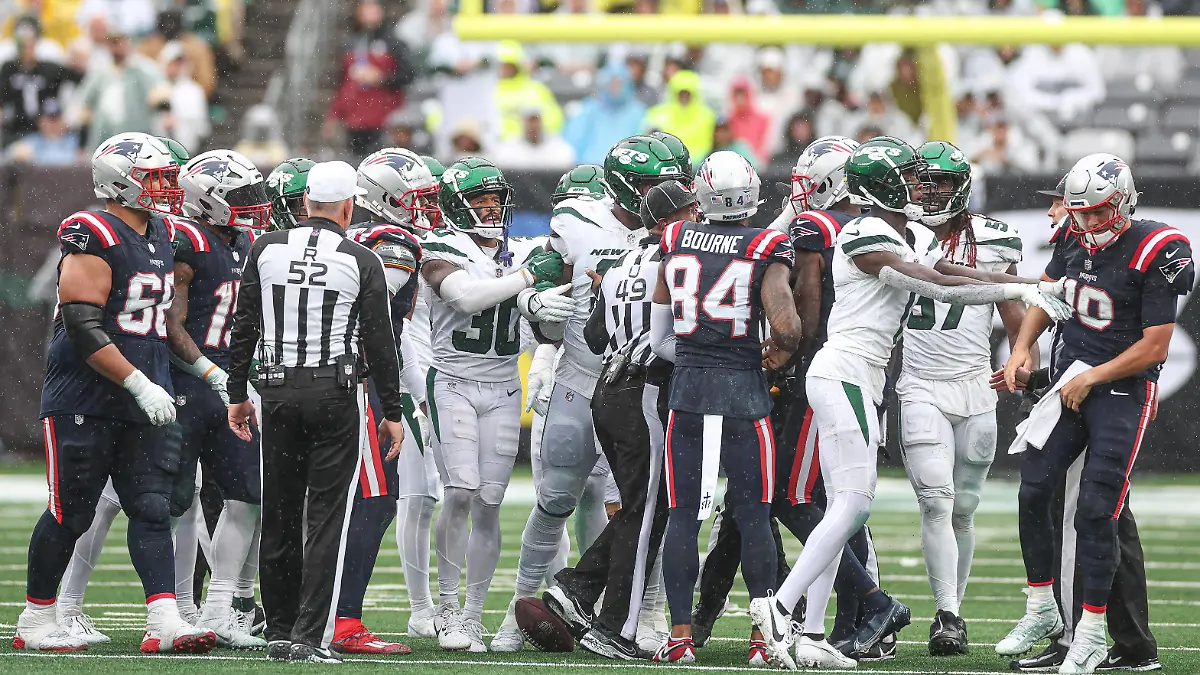 NFL, American Football Herren, USA New England Patriots at New York Jets Sep 24, 2023 East Rutherford, New Jersey, USA New York Jets cornerback Sauce Gardner 1 pushes New England Patriots quarterback Mac Jones 10 behind a group of players during the second half at MetLife Stadium. East Rutherford MetLife Stadium New Jersey USA, EDITORIAL USE ONLY PUBLICATIONxINxGERxSUIxAUTxONLY Copyright: xVincentxCarchiettax 20230924_szo_cb6_0130